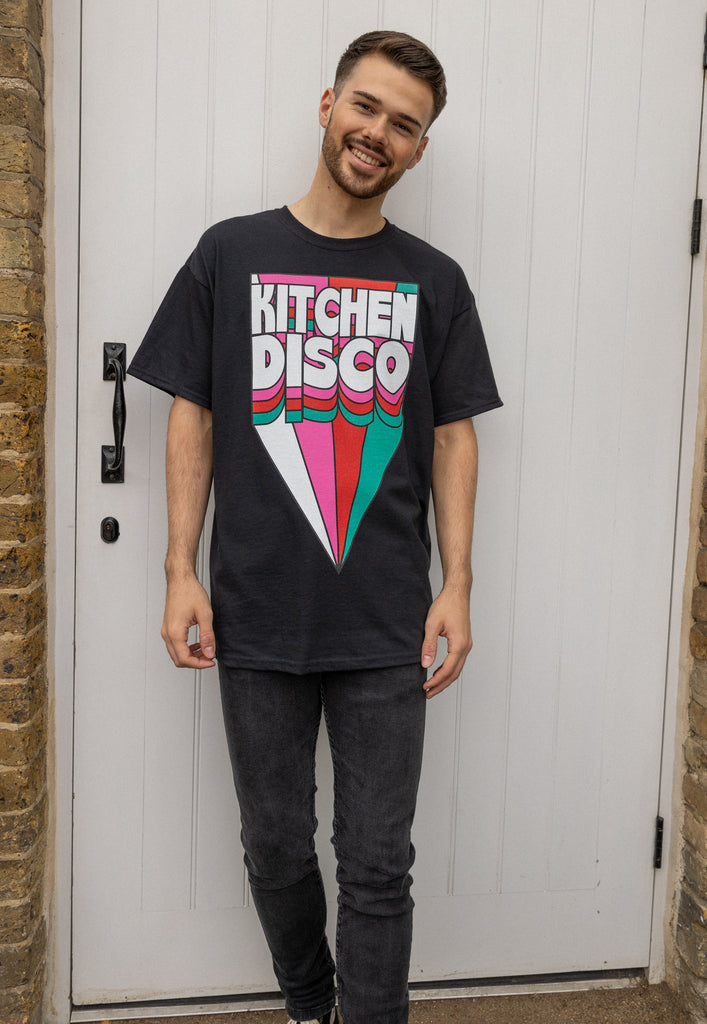 model is standing wearing black short sleeved t shirt with large graphic print in retro style with kitchen disco slogan