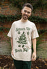 male model is wearing positive christmas slogan t shirt with cute tree chracter graphic and vintage green print
