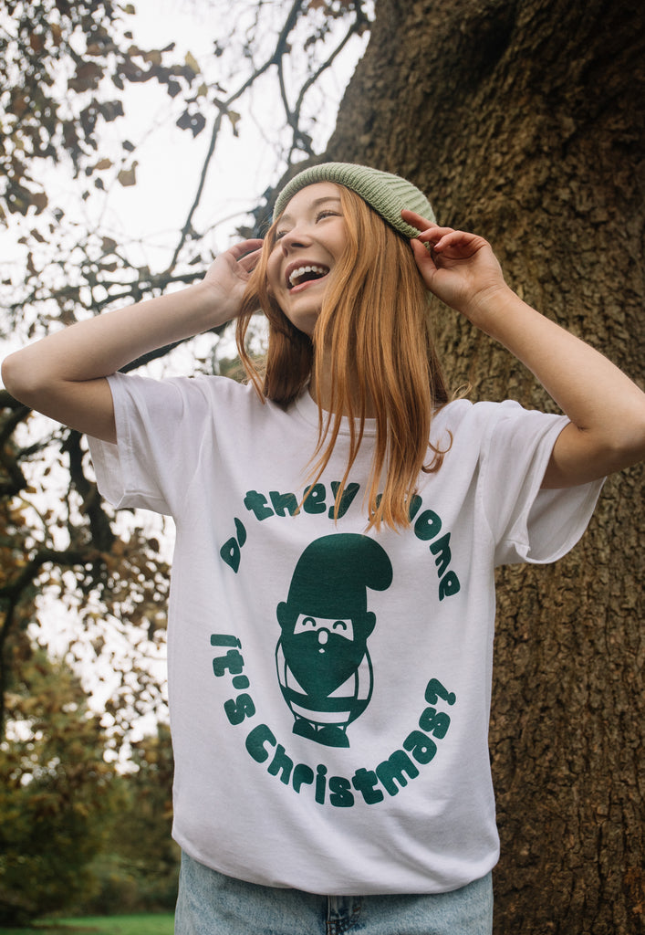 female model wears christmas t-shirt in white with green gnome print