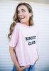 Model wears biscuit slogan tshirt in pastel pink