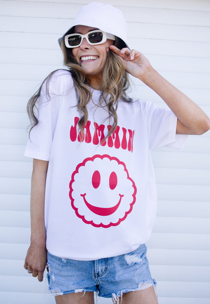 Model wears white tshirt with Jammin happy face biscuit graphic 