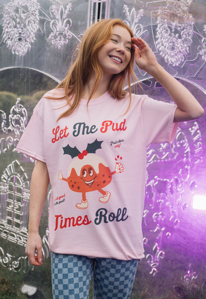 female model wears pink unisex fit christmas t shirt with vintage style pudding graphics and positive slogan