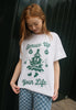 female model wears printed christmas t shirt in vintage style featuring christmas tree character graphic and punny slogan