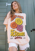 Model wears women's festival t-shirt with floral graphic and slogan