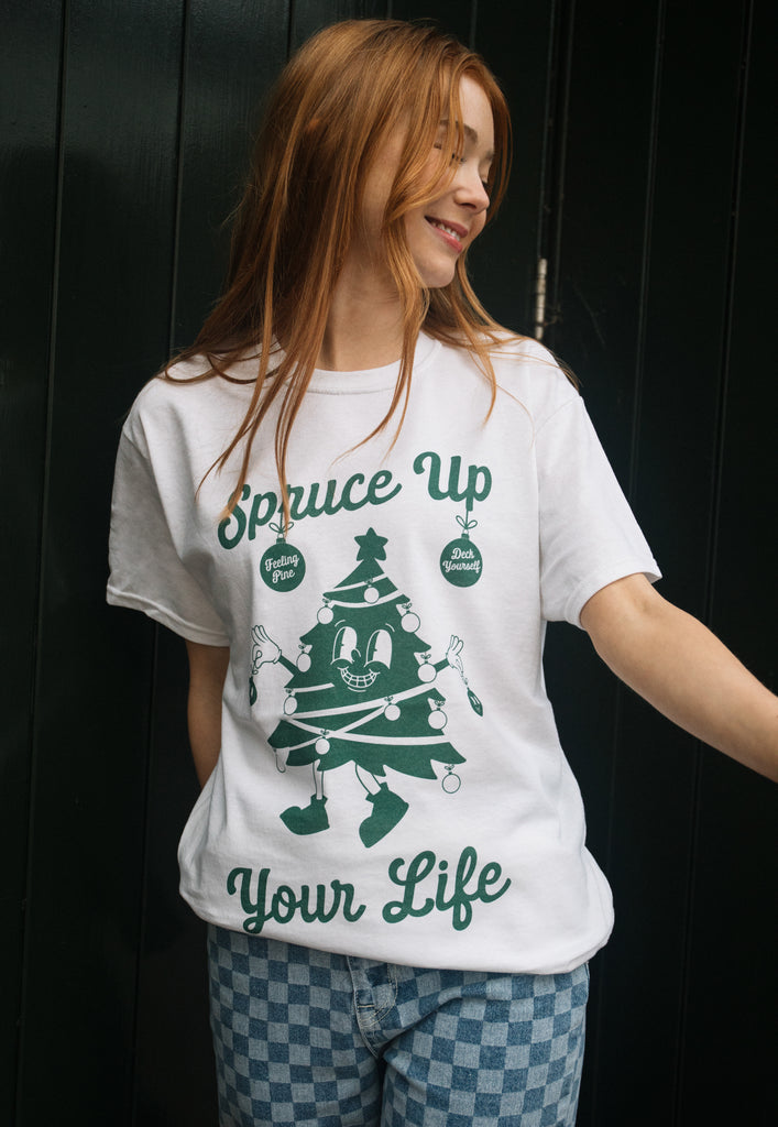 joyful image of female model wearing vintage style christmas t-shirt with christmas tree graphic and 'spruce up your life' slogan