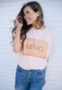 model is wearing peach coloured organic t shirt with photo print biscuit and be nice slogan