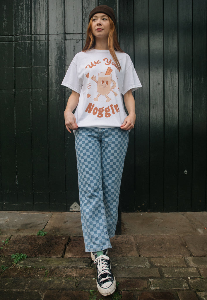 female model is wearing relaxed fit christmas t shirt with funny egg nog slogan and vintage style character print