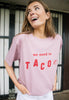 model wears pastel purple t-shirt wiith printed taco slogan