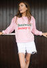 model is wearing pink casual jumper with printed sandwich society slogan on front