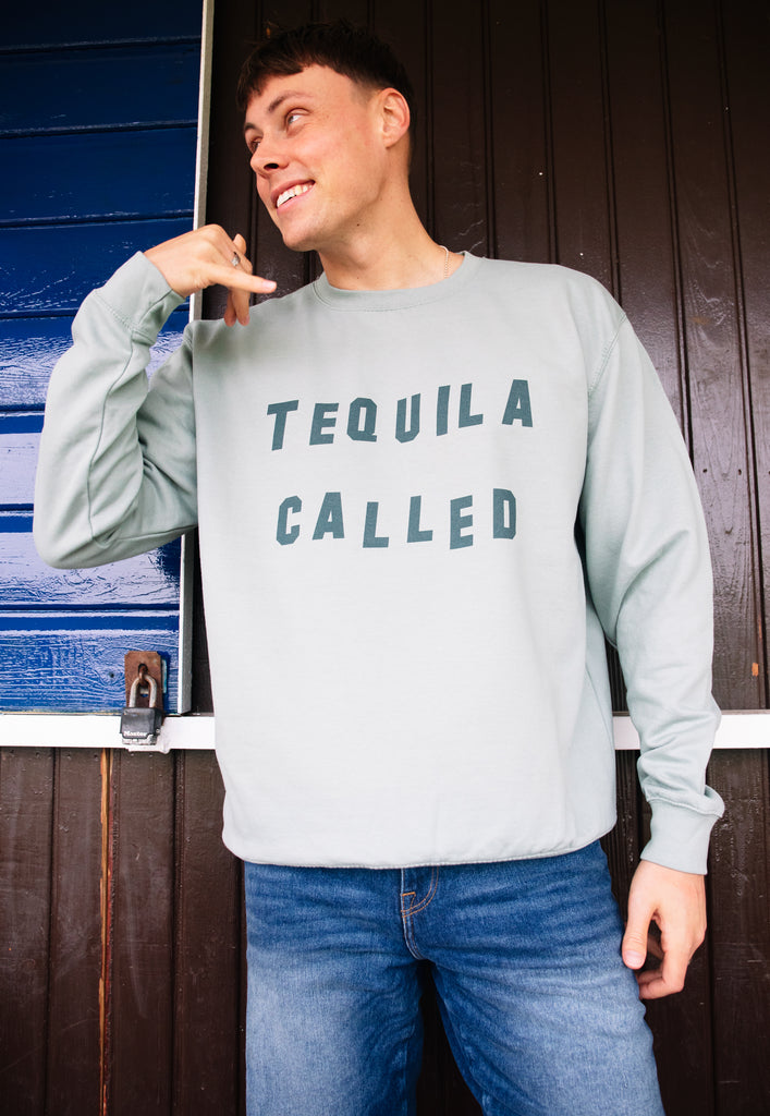 Model wears Dusty Green sweatshirt with Tequila Called slogan 