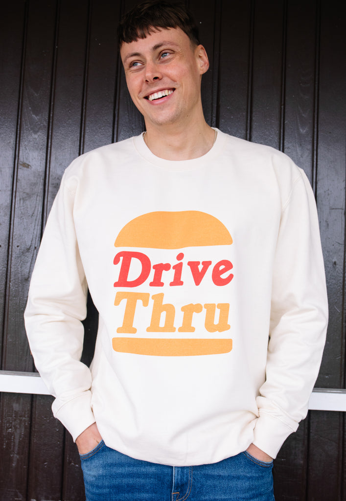 Model wears vanilla sweatshirt with Drive Thru slogan and burger graphic 
