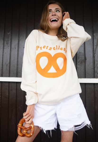 Model wears vanilla sweatshirt with Pretzellent slogan and pretzel graphic 