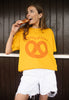 Model wears mustard shirt with Pretzellent slogan with pretzel graphic 