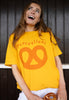 Model wears mustard tshirt with Pretzellent slogan and pretzel graphic 