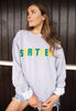 Model wears grey sweatshirt with Spritzer slogan 