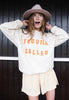 Model wears vanilla sweatshirt with Tequila Called printed slogan 