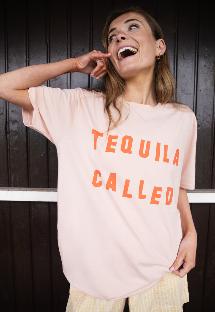 Model wears dusty peach tshirt with Tequila called slogan