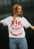 female model wears christmas t shirt in white with mince pie character graphic and punny slogan in red print