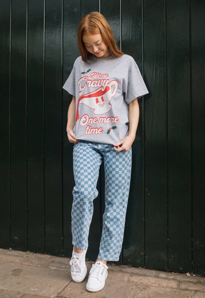 female model wears relaxed fit vintage style christmas t shirt in grey with gravy boat character and slogan