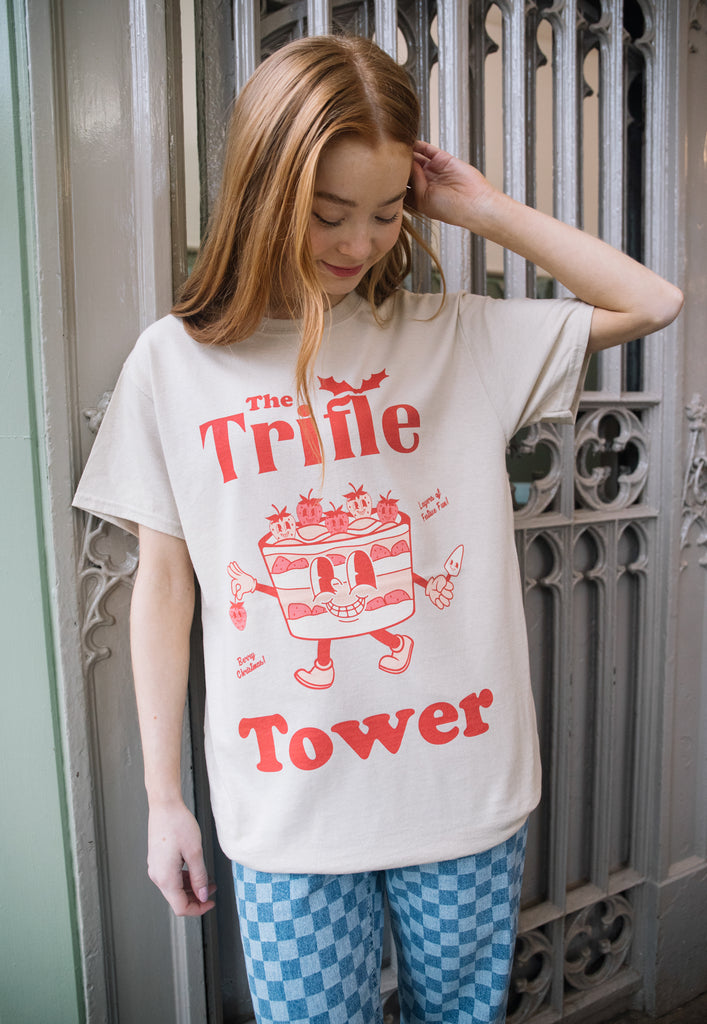female model is wearing printed christmas t shirt with funny trifle character and slogan in red print