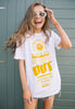 Model wears white t-shirt printed with "Spaced Out" slogan in bright yellow and festival style vegetable graphics 