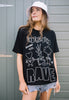 Model is wearing black relaxed fit summer t-shirt with printed 'underground rave' slogan and vintage style veggie character graphics