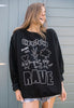 Model wears black sweatshirt with printed "underground rave" slogan and vegetable characters 