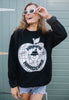 Model is wearing black sweater with happy hardcore slogan and apple graphics printed on front of garment