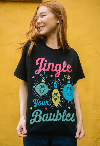 colourful image of female model wearing black christmas t-shirt with bright vintage graphic print and 'jingle your baubles' slogan