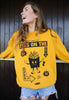 female model is wearing mustard sweatshirt with vintage french fries print in black and eyes on the fries slogan