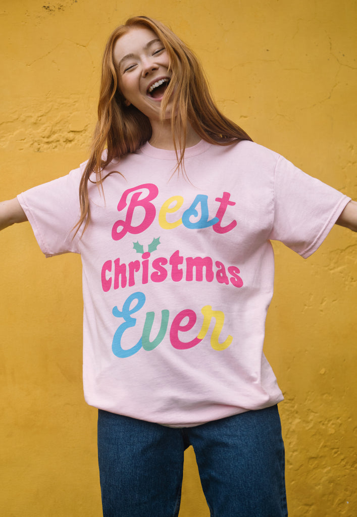 female model wears pink christmas t shirt with positive slogan in bright print
