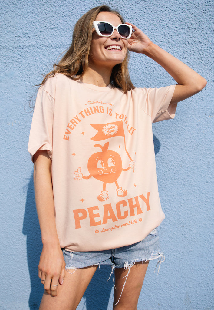Model wears vintage style peach slogan tshirt