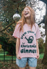 model wears pink relaxed fit christmas t shirt with grow your own slogan and watering can graphic disco ball in background