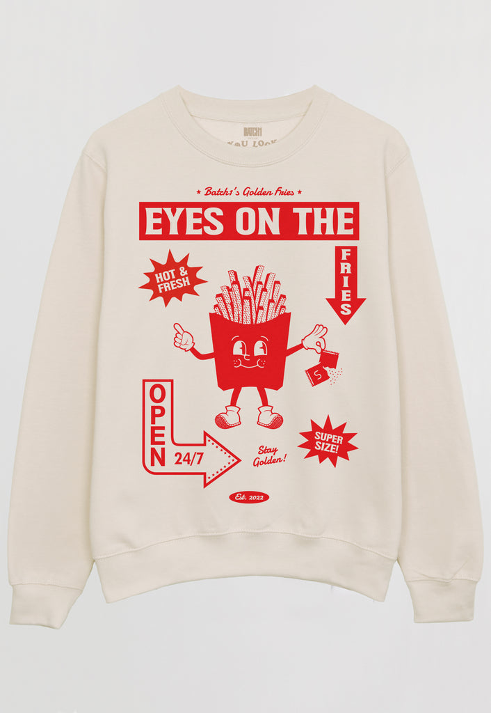 Flatlay of vanilla sweatshirt with Eyes on the Fries slogan and french fries character graphic