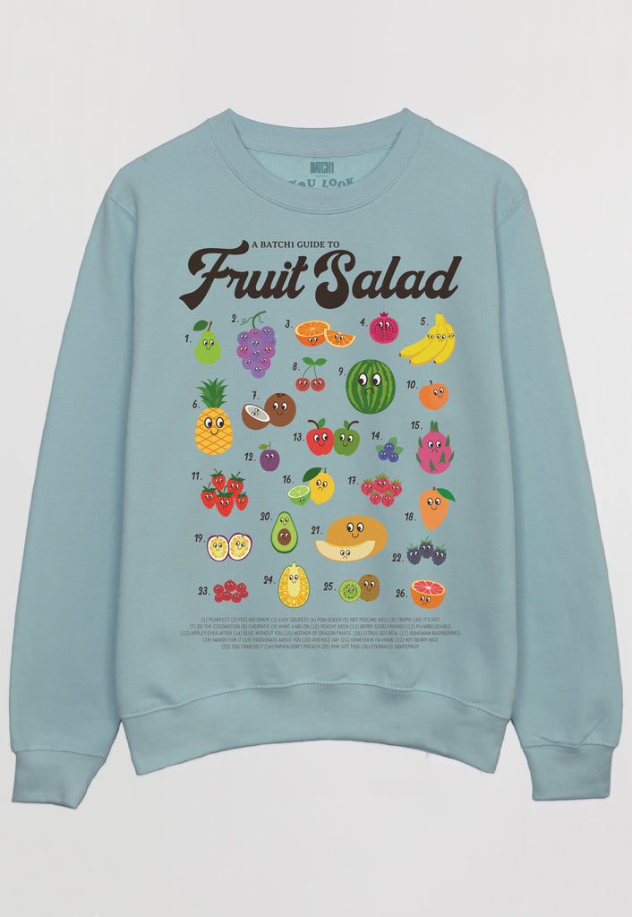 Flatlay of women's pastel green sweatshirt with fruit salad slogan and fruit characters