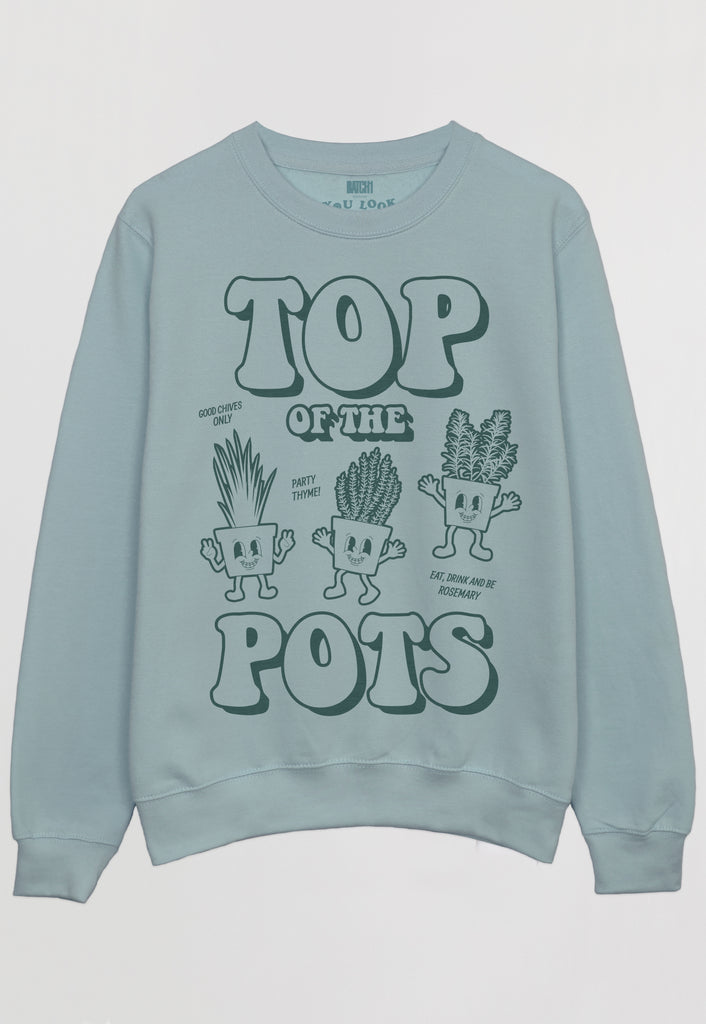 Flatlay of dusty green sweatshirt with Top of The Pots festival slogan and plant pot character graphic