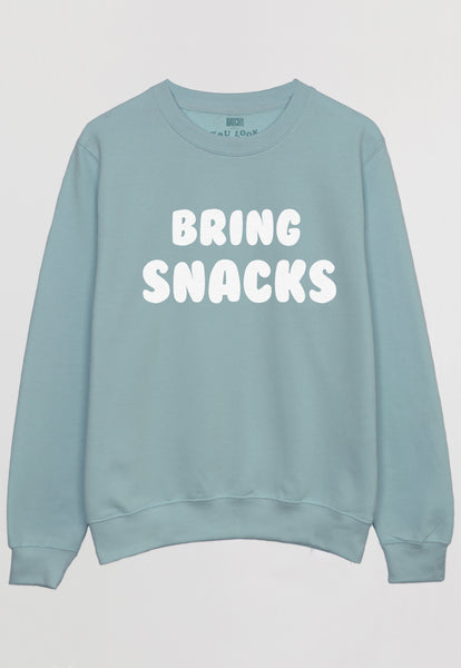 Flatlay of pastel green sweatshirt with bring snacks slogan in white print