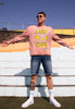 Model wears dusty pink sweatshirt with Acid House festival slogan and lemon character graphic 