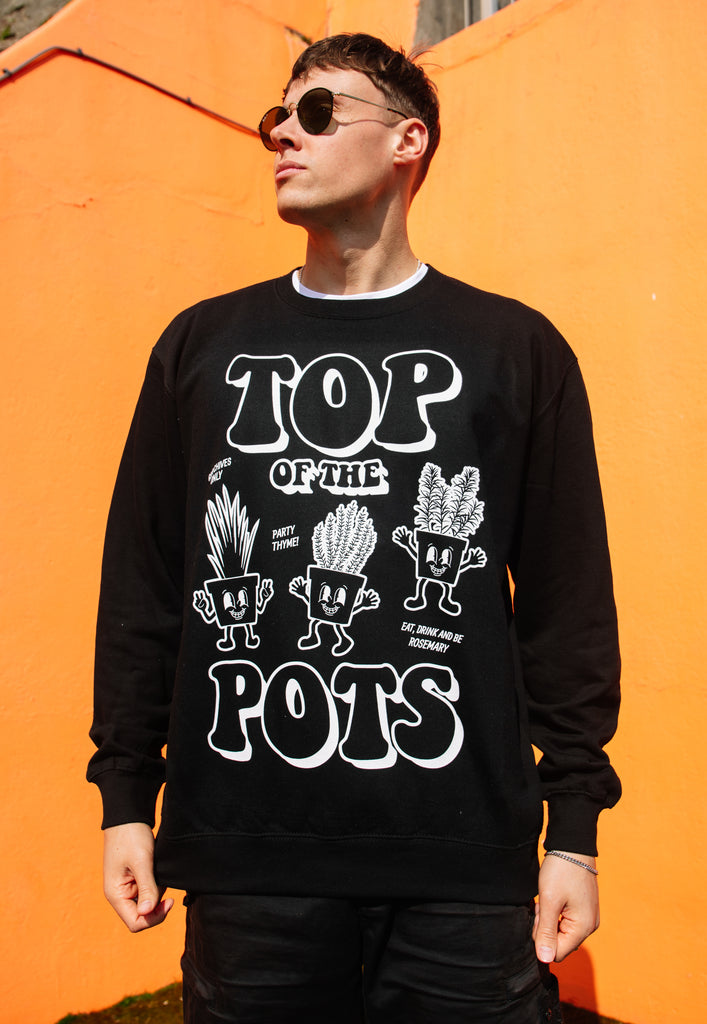 Model wears black sweatshirt with Top of The Pots festival slogan and plant pot character graphic