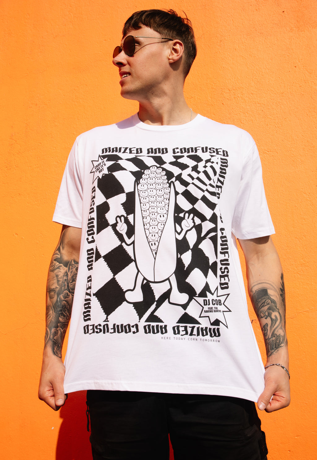 male model wears white printed t shirt with black and white print in 90s rave festival style and maized and confused slogan