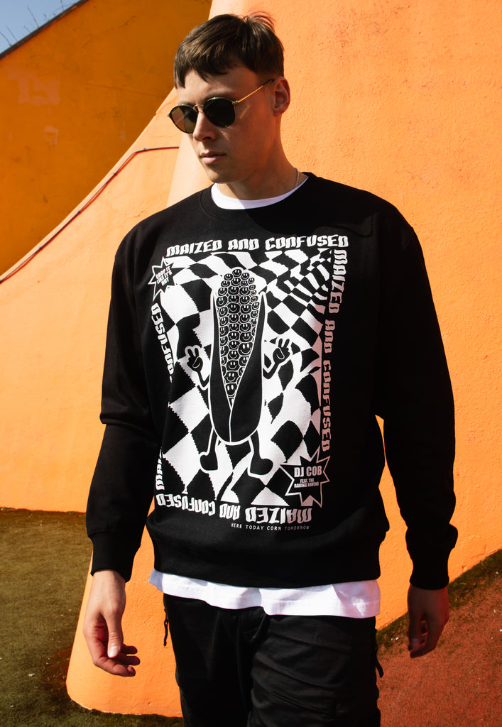 male model wears black sweater with printed rave logo and maized and confused slogan