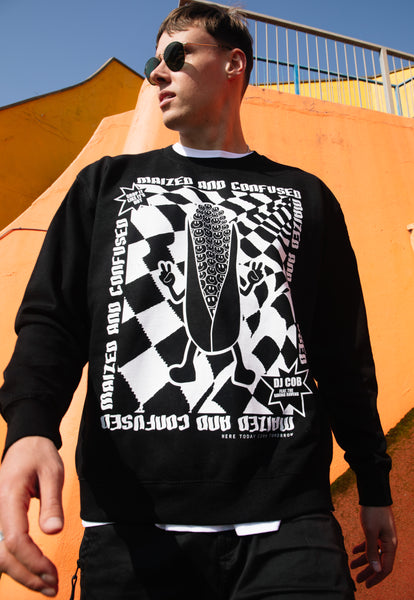 male model is wearing black sweatshirt with white printed rave graphics and maized and confused slogan with corn character