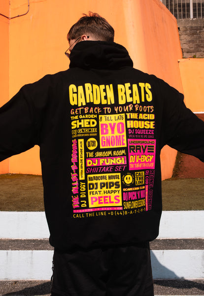 model wears black hoodie with Garden Beats festival slogan and poster graphic back print 