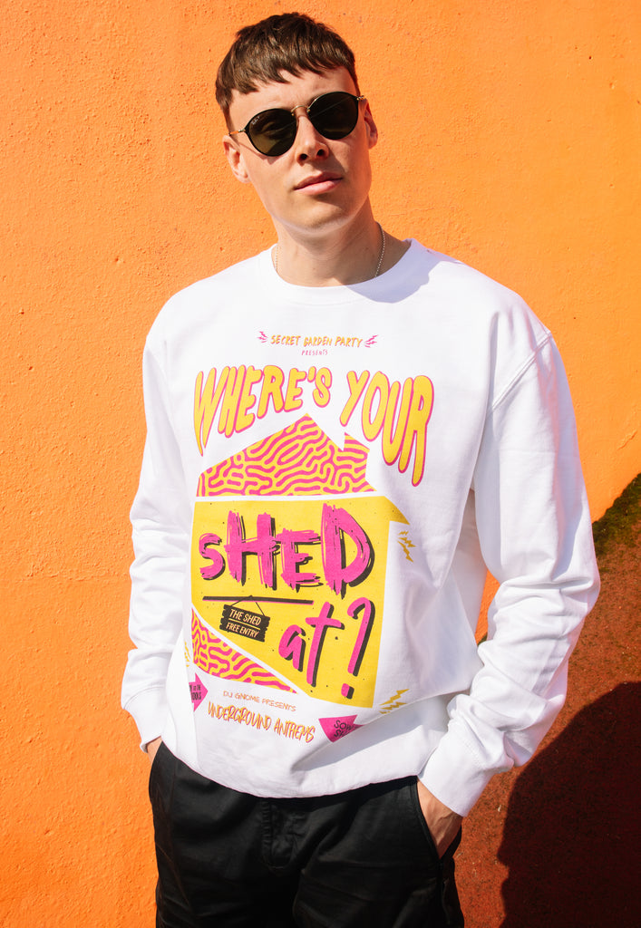 Model wears white sweatshirt with Where's Your Shed At festival slogan 