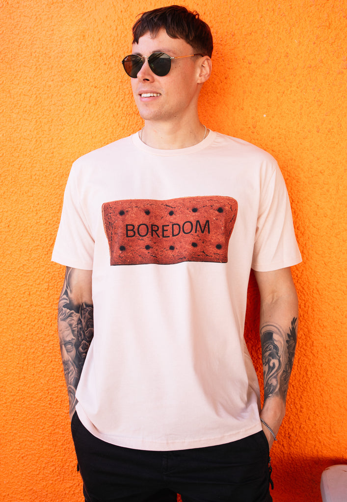 Model wears dusty peach tshirt with Bored slogan on biscuit graphic 