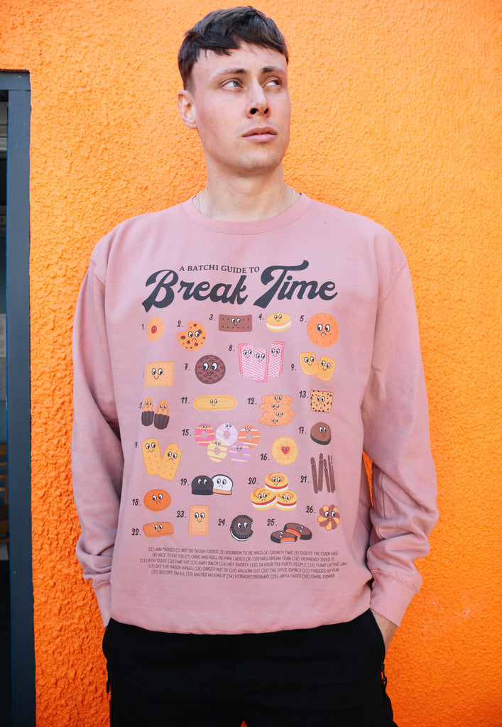 Model wears dusty pink sweatshirt with Break Time slogan and biscuit guide graphic