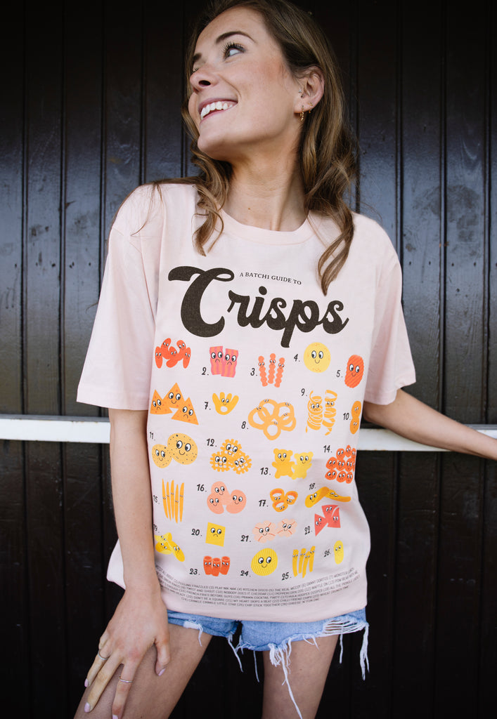 Model wears dusty peach tshirt with A guide to Crisps slogan and crisps character graphic